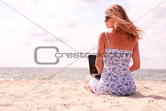 girl with laptop on the beach