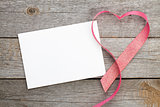Blank valentines greeting card and red heart shaped ribbon