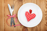 Valentine's Day toy heart over plate with silverware