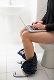 young man in toilet using laptop