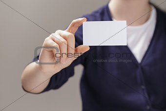 female teen holding empty business card in front of camera