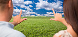 Couple Framing Hands Around Space in Grass Field