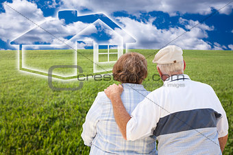 Senior Couple Standing in Grass Field Looking at Ghosted House
