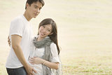 Happy pregnant Asian couple
