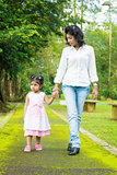 Indian mother and daughter walking outdoor.