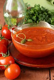 tomato soup with fresh vegetables and capers in a glass bowl