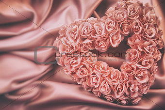 Heart made of pink roses on satin