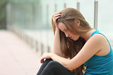 Teenager girl sitting outdoor depressed