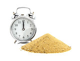 Alarm clock with pile of sand  of white background