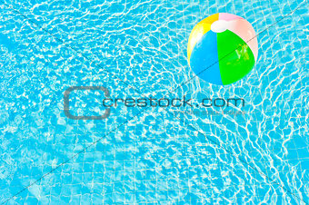 multicolored ball and turquoise water with ripples