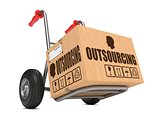 Outsourcing - Cardboard Box on Hand Truck.