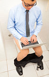 businessman  using time well working  in toilet with laptop .