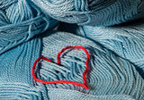 Knitted red heart on blue