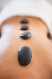 Closeup on young woman receiving hot stone massage