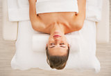 Relaxed young woman laying on massage table