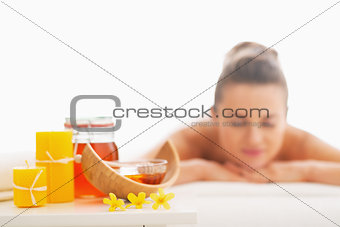 Closeup on honey spa therapy ingredients and relaxed young woman
