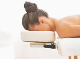 Relaxed young woman laying on massage table