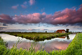 farmhouse and river at dramatic sunset