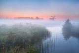 windmill and river with dense fog
