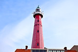 big red lighthouse over blue sky