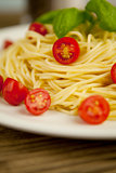 fresh tasty pasta with tomato and basil on table