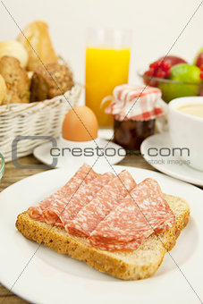tasty breakfast with salami toast on table