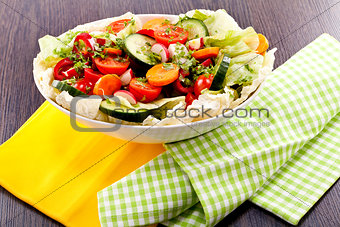 fresh mixed colorful salad on wooden table 