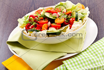 fresh mixed colorful salad on wooden table 