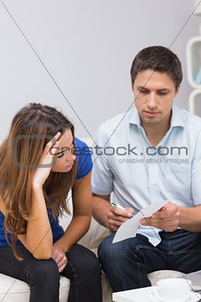 Stressed couple paying their bills at home