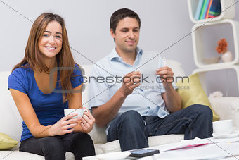 Portrait of a smiling couple with bills at home
