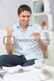 Smiling man paying his bills at home