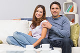 Relaxed couple sitting on sofa at home