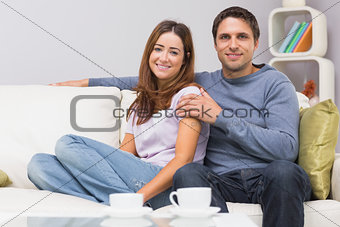 Relaxed couple sitting on sofa at home