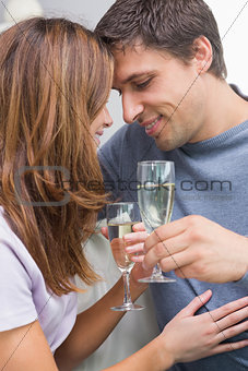 Close-up of a romantic couple with flutes at home