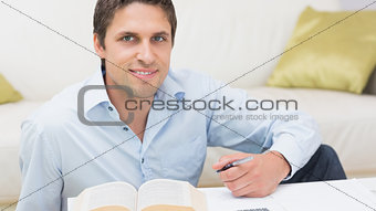Portrait of a man with pen and book at home