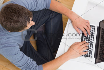 Overhead view of a man using laptop at home