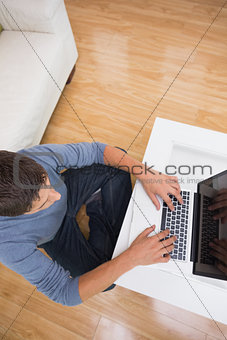 Overhead view of a man using laptop in living room