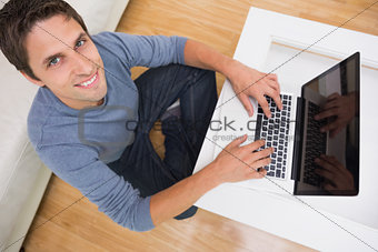 Overhead portrait of a man using laptop in living room