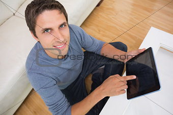 Overhead portrait of man using digital tablet in living room