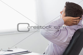 Thoughtful relaxed businessman sitting in office