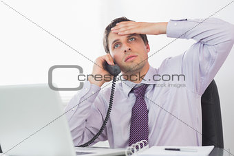 Worried businessman on call at desk