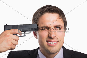 Close-up of a businessman holding a gun to head