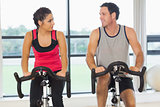Man and woman working out at spinning class