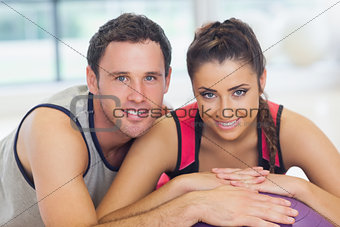 Young woman and man with cropped fitness ball at a gym