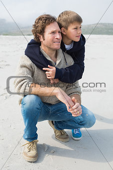 Casual man and son relaxing at beach