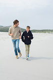 Young man and son jogging at beach