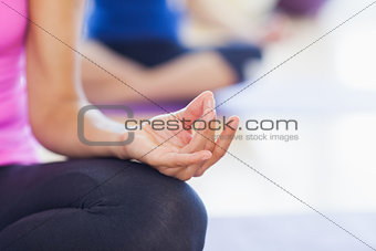 Close-up of cropped sporty women in lotus pose
