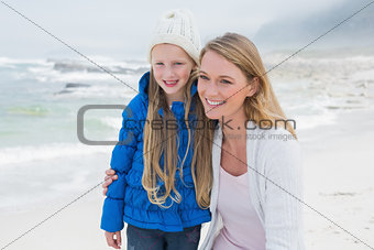 Cute girl with smiling mother at beach