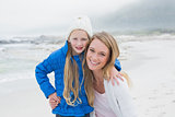 Cute young girl with smiling mother at beach