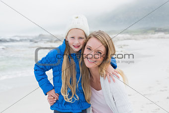 Cute young girl with smiling mother at beach